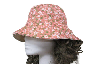 Pink floral bucket hat on a mannequin head against a white background