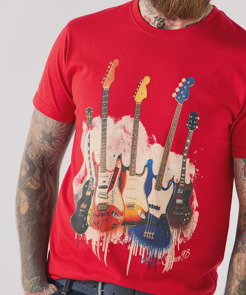 Red t-shirt with guitar design worn by a person with tattoos on a plain background